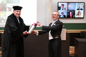 Wim van den Bouwhuijsen (rechts) krijgt zijn doctorsbuil uit handen van promotor Jos Lichtenberg. Foto | Photodette / TU/e