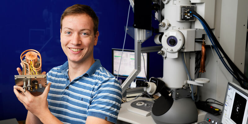 [Translate to English:] Wouter Verhoeven voor een elektronenmicroscoop met zijn bundelknippende resonator. Foto | Bart van Overbeeke