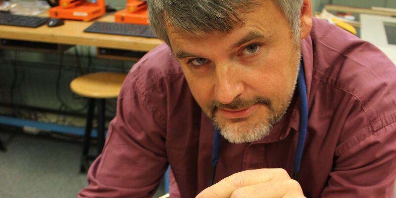 Peter van de Graaf met zijn uitvinding tussen duim en wijsvinger. Foto | Hogeschoolkrant win’ Windesheim
