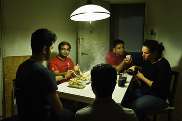 A parody on the famous Van Gogh painting 'De aardappeleters': 'The Kapsalon eaters'. Photo | Bart van Overbeeke