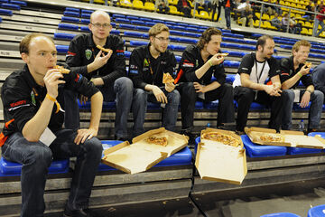 Het team van Tech United onder leiding van Pieter van Zutven (links) heeft een korte lunchpauze met pizza's. l Foto Bart van Overbeeke
