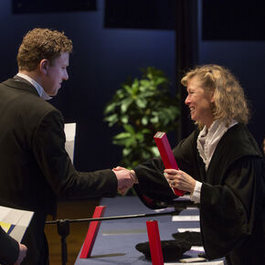 Bouwkundedecaan Elphi Nelissen (rechts) overhandigt het alumnigeschenk aan Tom Steegh. Foto | Vincent van den Hoogen