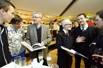 Jos Bedet (L) en Sjir Nijssen bladeren door het lustrumboek. Foto | Bart van Overbeeke