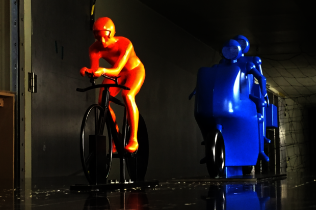 Racing cyclist benefits from motorcycle right behind him