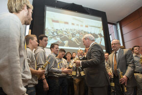 Bestuurders Hans van Duijn en Jo van Ham delen champagne uit. Foto | Rien Meulman