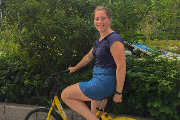 Paula op een van de vele deelfietsen die in de straten van Shenzhen te vinden zijn. Foto | Privé-archief Paula Bartelds