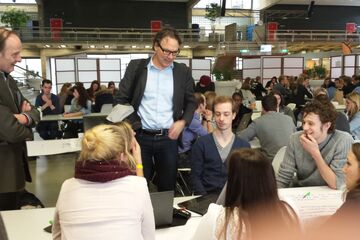 Wethouder Staf Depla informeert bij een groepje studenten naar hun idee.