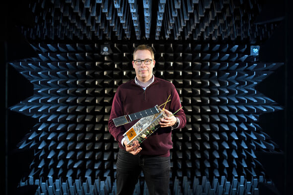 Mark Bentum in antennemeetkamer met een C3 nano-satelliet. Foto | Bart van Overbeeke