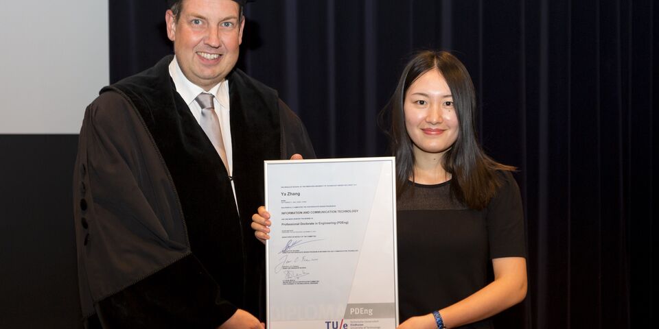 De Chinese Ya Zhang ontvangt uit handen van dean Jan Fransoo het 2500ste PDEng-diploma. Foto | Arne Olivier