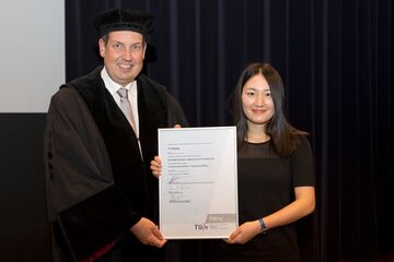 De Chinese Ya Zhang ontvangt uit handen van dean Jan Fransoo het 2500ste PDEng-diploma. Foto | Arne Olivier