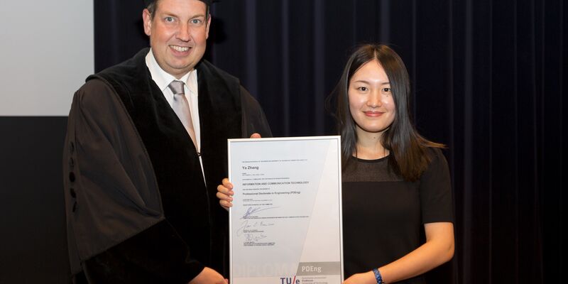De Chinese Ya Zhang ontvangt uit handen van dean Jan Fransoo het 2500ste PDEng-diploma. Foto | Arne Olivier