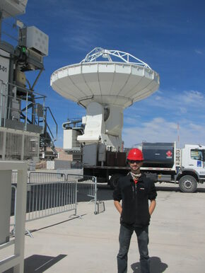 Tom standing in front of one of the 66 ALMA telescopes.