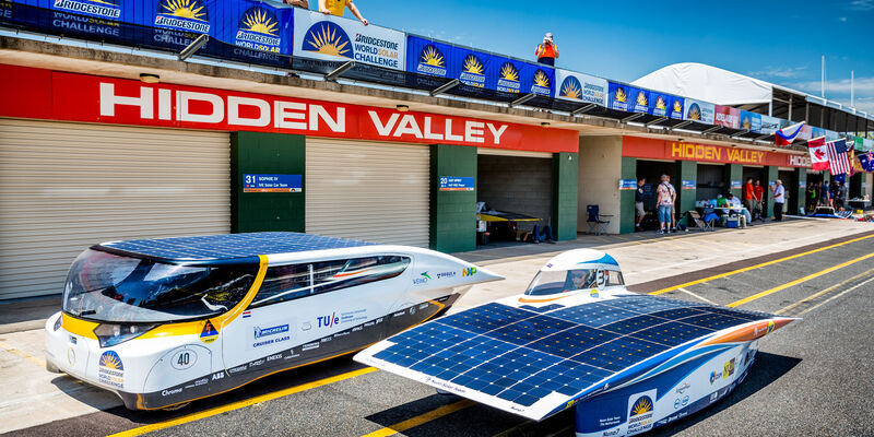 De Nederlandse deelnemers Stella (links) en Nuna7 in World Solar Challenge 2013 naast elkaar op het circuit in Darwin, Australië. Foto | Jorrit Lousberg