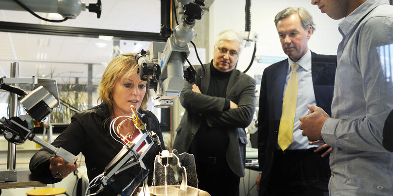 Minister Jet Bussemaker with the TU/e robot for eye surgery. Photo | Bart van Overbeeke
