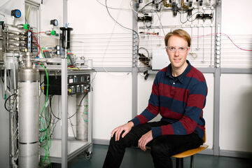 Niek de Nooijer naast een membraanreactor. Foto | Bart van Overbeeke