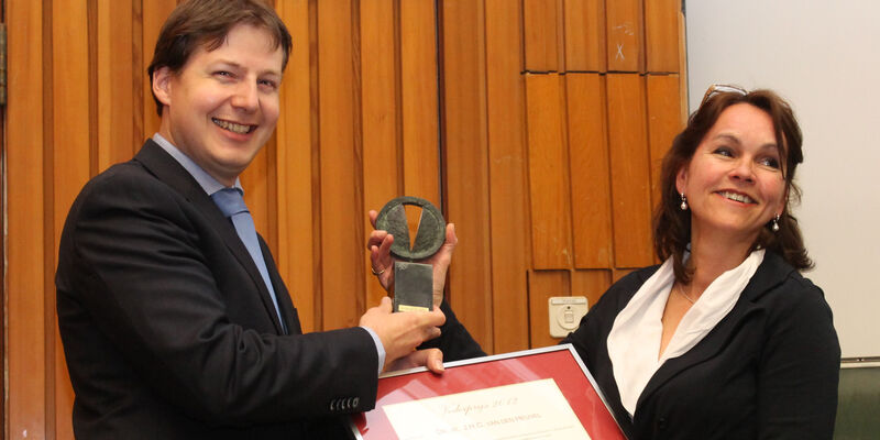 Dr.ir. Johan van den Heuvel neemt de prijs in ontvangst uit handen van Francoise Olthof-Kosters, voorzitter van de stichting wetenschappelijk radiofonds Veder.