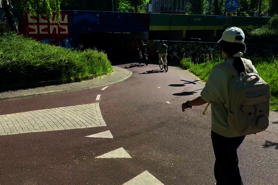 Cyclists, moped riders and pedestrians move crisscross through each other