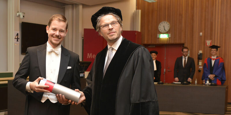 Jorn van der Pol ontvangt zijn bul van hoogleraar Remco van der Hofstad. Foto | Rien Meulman