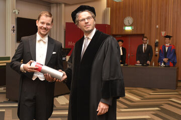 Jorn van der Pol ontvangt zijn bul van hoogleraar Remco van der Hofstad. Foto | Rien Meulman