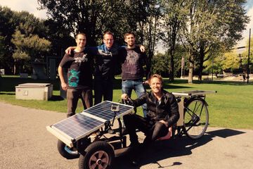 Studenten Frank Rams, Jelmer van de Wiel en Arjo van der Ham, met op de zonnewagen presentator Bart Meijer.