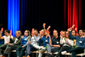 Voting by holding up a red or green piece of paper. Photo | Bart van Overbeeke